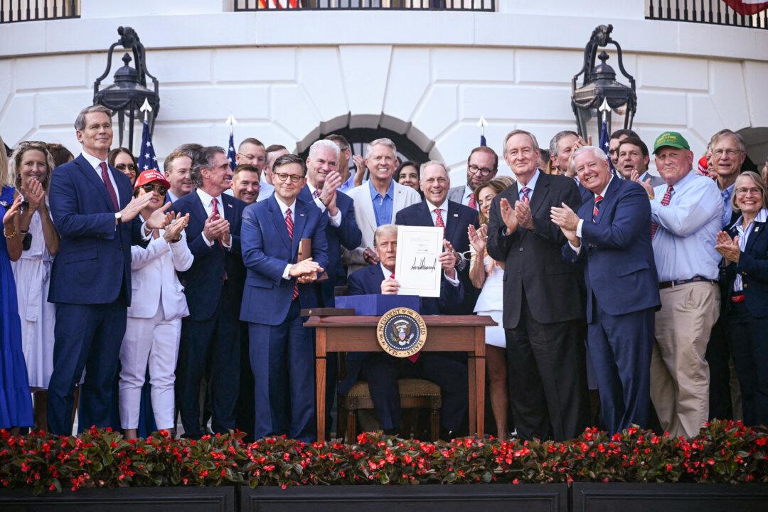 President Donald Trump shows his signature on the “One Big Beautiful Bill Act” at the White House on July 4, 2025. (Brendan Smialowski/POOL/AFP via Getty Images)