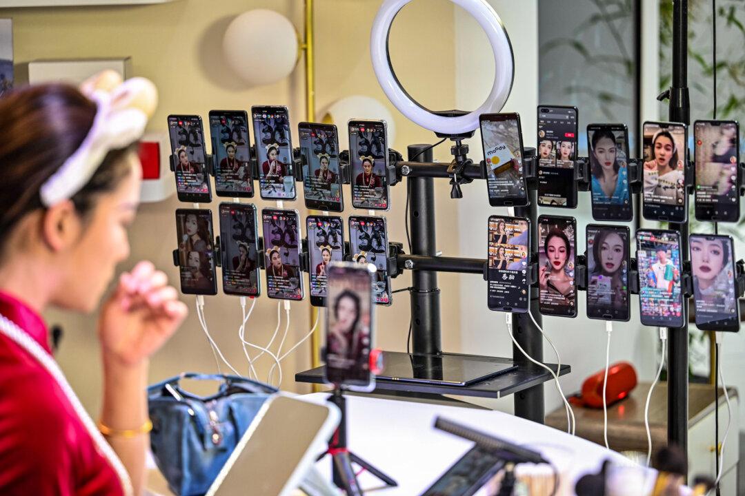 A woman applies makeup in a live studio at a Huawei booth during the Mobile World Congress in Shanghai on Feb. 23, 2021. (Hector Retamal/AFP via Getty Images)