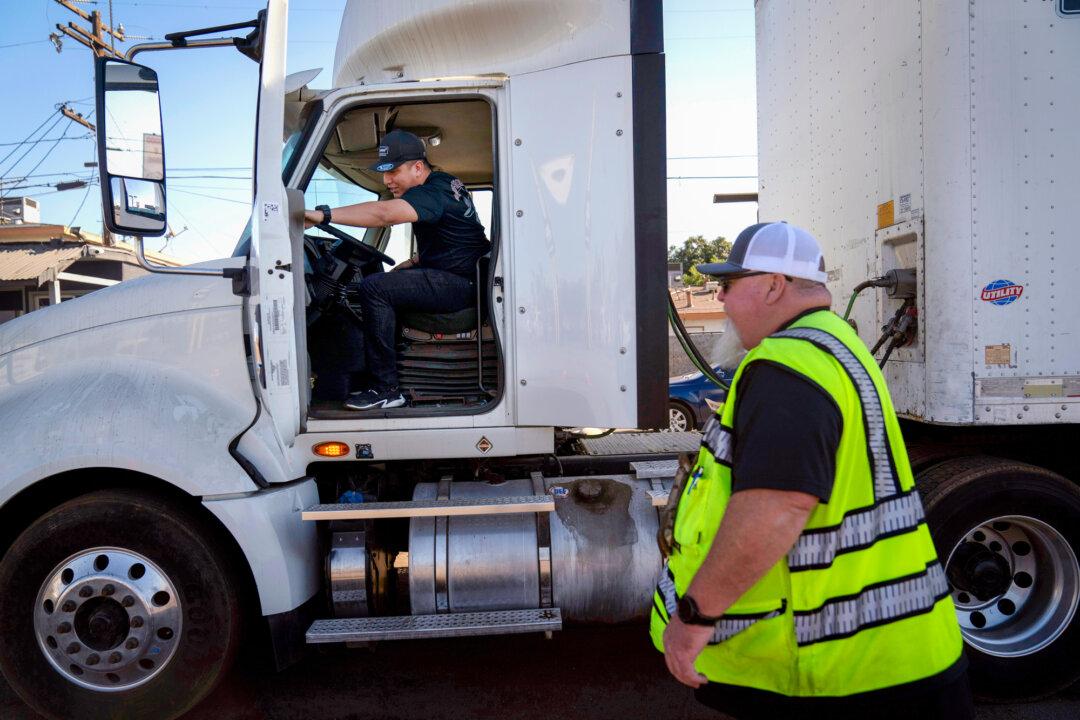 A student driver gets in a truck as the instructor watches in California on Nov. 15, 2021. The U.S. Transportation Department accused California, Washington state, Texas, South Dakota, Pennsylvania, and Colorado of improperly issuing commercial driver's licenses to noncitizens after a federal audit. (Jae C. Hong/AP Photo)