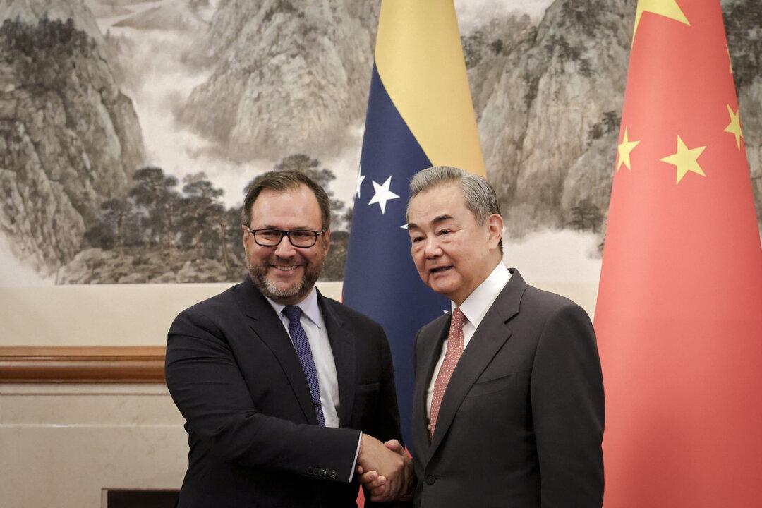 Chinese Foreign Minister Wang Yi (R) and Venezuela’s Foreign Minister Yvan Gil shake hands before their meeting at the Diaoyutai State Guesthouse in Beijing on May 12, 2025. (Florence Lo/POOL/AFP via Getty Images)