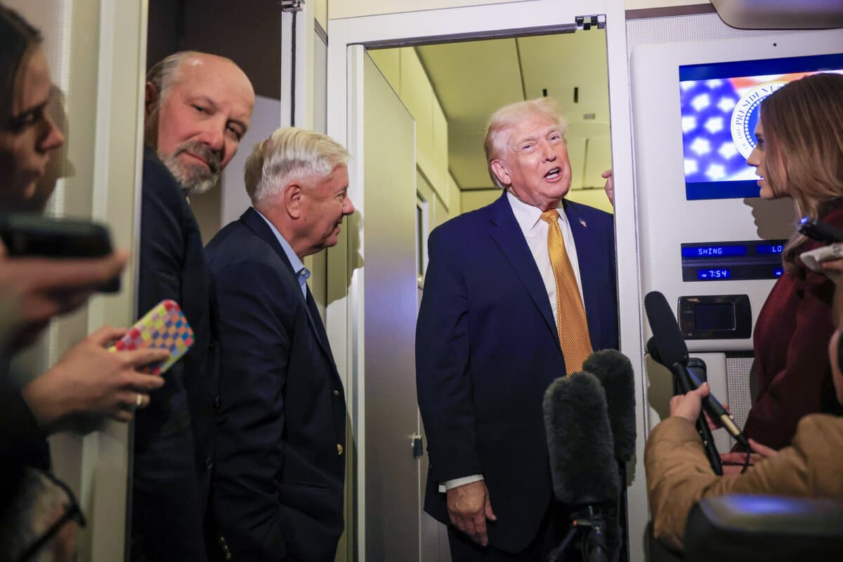 President Donald Trump, Commerce Secretary Howard Lutnick (L), and Sen. Lindsey Graham (R-S.C.) (C) speak to the media aboard Air Force One en route to Washington on Jan. 4, 2026. (Joe Raedle/Getty Images)