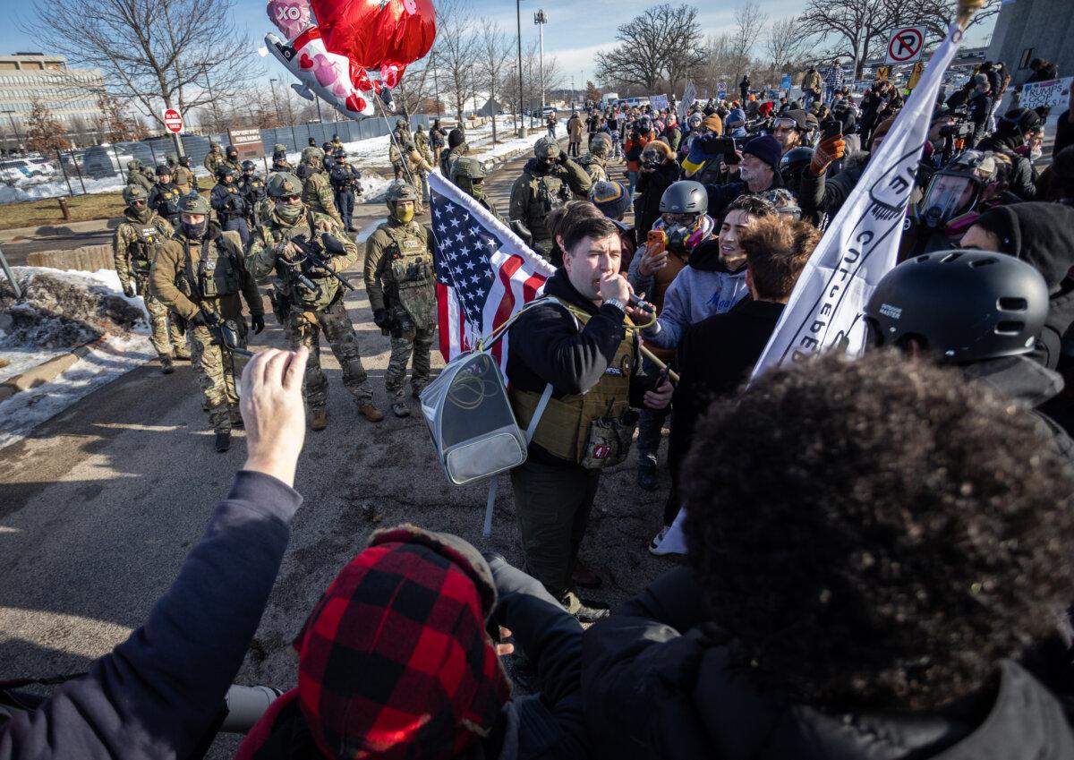 Protesters face off with federal officers in front of the Bishop Henry Whipple Federal Building in Minneapolis on Jan. 9, 2026. (John Fredricks/The Epoch Times)