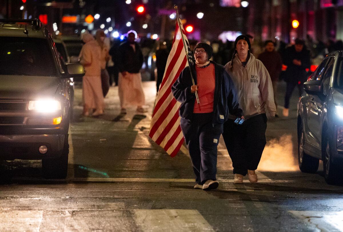 Protesters against Immigration and Customs Enforcement operations walk down a street in Minneapolis on Jan. 9, 2026. (John Fredricks/The Epoch Times)