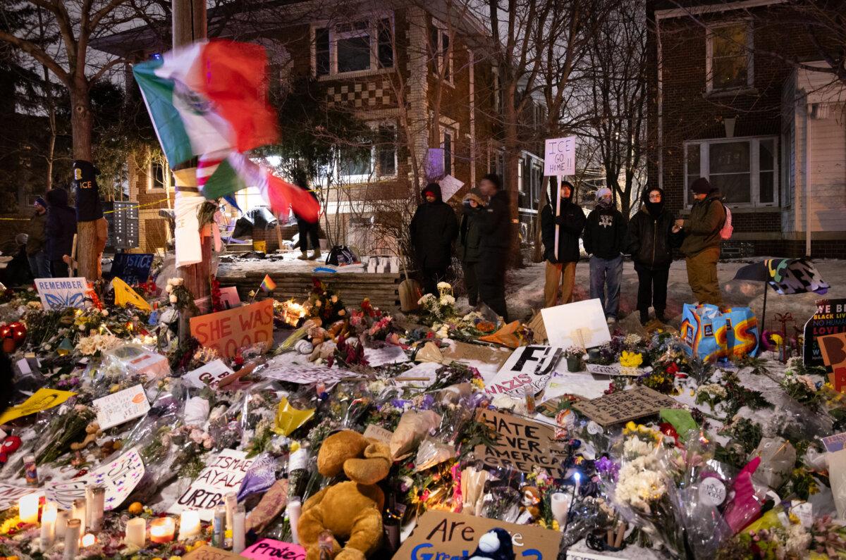 People gather at a makeshift memorial for Renee Good, who was fatally shot at the location during an Immigration and Customs Enforcement operation, in Minneapolis, on Jan. 10, 2026. (John Fredricks/The Epoch Times)