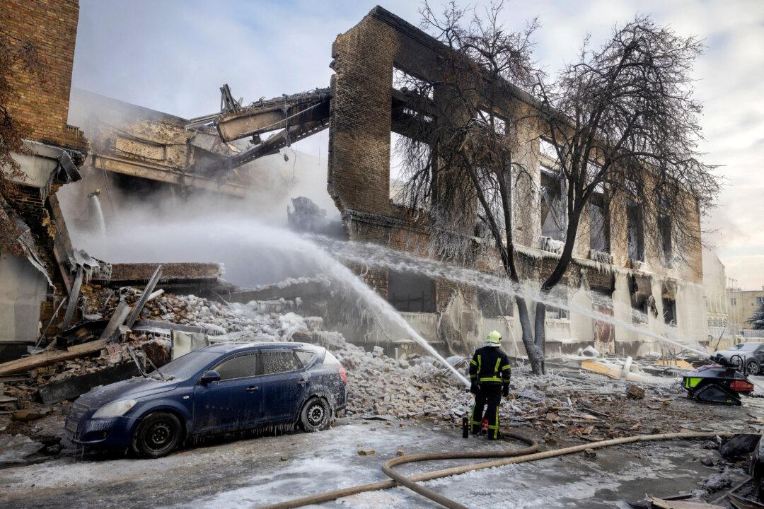 A firefighter works at the site of a building that was hit by a Russian drone, amid Russia's attack on Ukraine, in Kyiv, Ukraine, on Jan. 12, 2026. (Thomas Peter/Reuters)