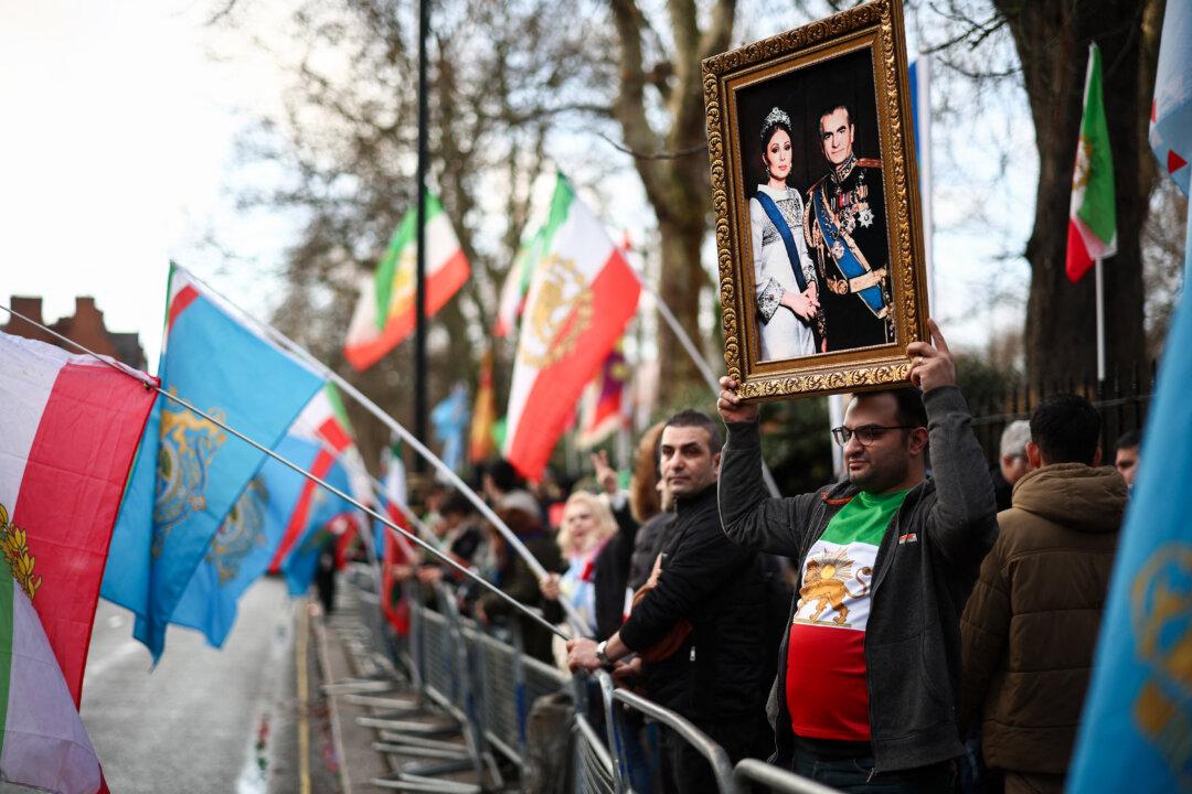 An anti-Iran regime protester holds up a photo of Mohammad Reza Pahlavi, the former Shah of Iran, outside the Iranian Embassy in London, on Jan. 12, 2026. (Henry Nicholls/AFP via Getty Images)