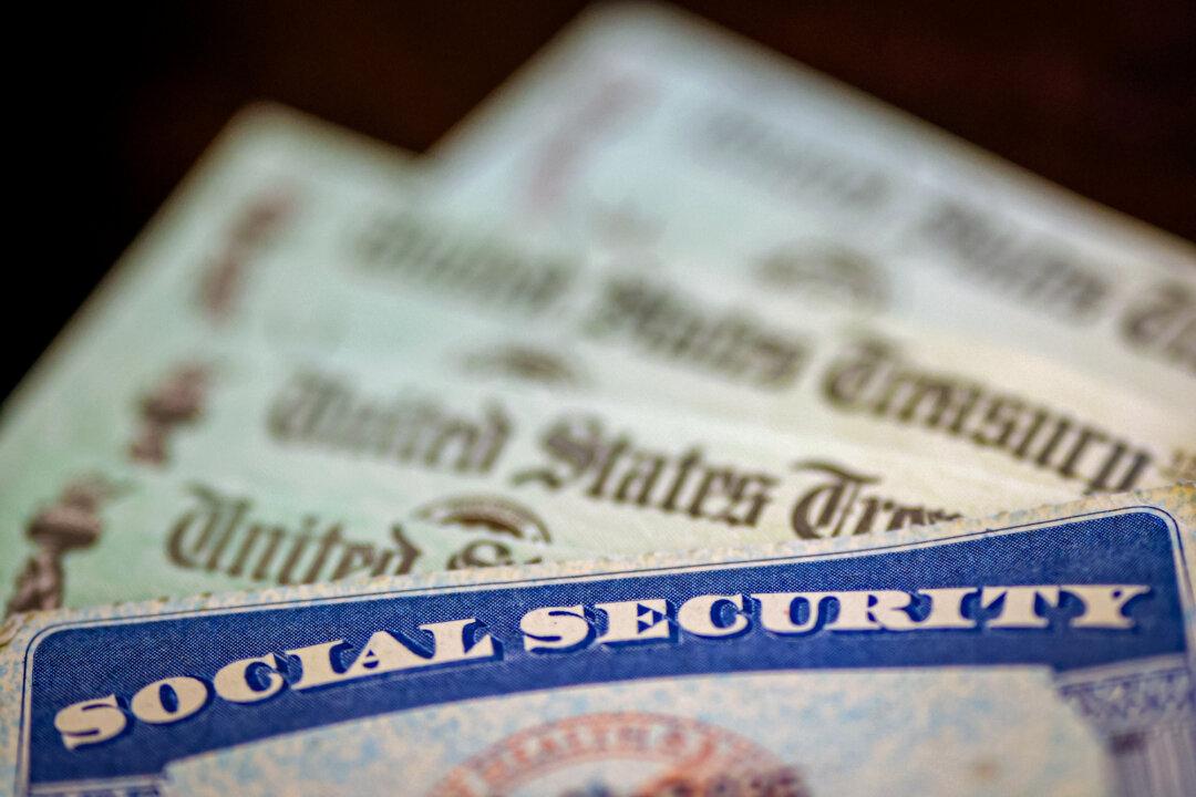 A Social Security card sits alongside checks from the U.S. Treasury in this photo illustration in Washington on Oct. 14, 2021. The Government Accountability Office found evidence of Obamacare enrollment fraud involving fake accounts created with Social Security numbers of people reported dead before enrollment. (Kevin Dietsch/Getty Images)