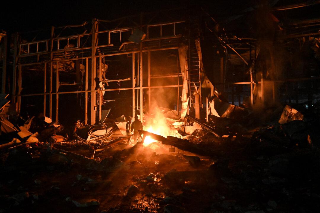 Ukrainian firefighters work at the site of a heavily damaged Nova Poshta postal company terminal following an air strike in a village outside Kharkiv, on Jan. 13, 2026, amid the Russian invasion of Ukraine. A Russian attack on Ukraine's northeastern city of Kharkiv killed four people and wounded several others, the regional governor said. (Sergey Bobok/AFP via Getty Images)