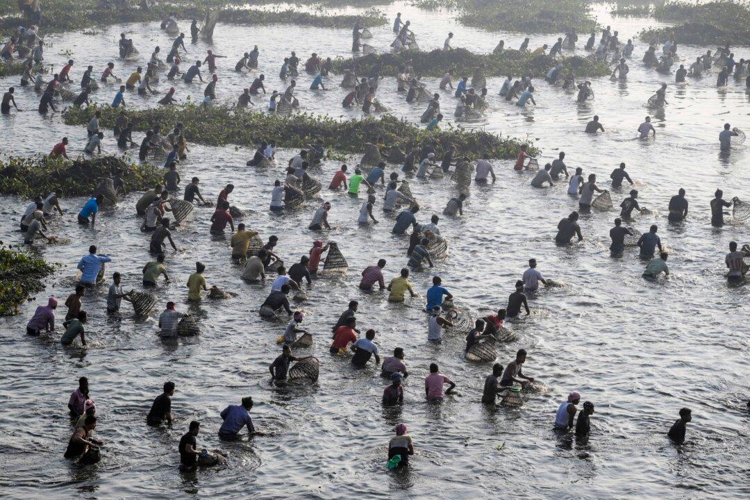 Villagers participate in a community fishing event on the occasion of the ‘Bhogali Bihu’ festival to mark the end of the harvesting season at Bomani Beel, a lake in the Morigaon district of Assam, India, on Jan. 13, 2026. (Biju Boro/AFP via Getty Images)