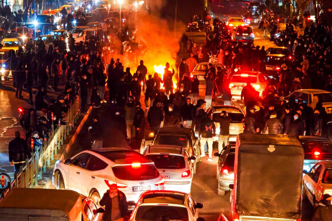 (Top Left) Iranians block a street, and vehicles are set on fire during a protest in Tehran, Iran, on Jan. 8–9, 2026. (Top Center) A vehicle burns during protests in Tehran, Iran, on Jan. 8, 2026. (Top Right) Iranians gather while blocking a street during a protest in Tehran, Iran, on Jan. 9, 2026. (Bottom Left) People gather during a protest in Tehran, Iran, on Jan. 8, 2026. (Bottom Center) People gather during a protest in Tehran, Iran, on Jan. 8, 2026. (Bottom Right) A dumpster burns during unrest in Tehran, Iran, on Jan. 8, 2026. (MAHSA/Middle East Images/AFP via Getty Images, Khoshiran/Middle East Images/AFP via Getty Images, Anonymous/Getty Images)