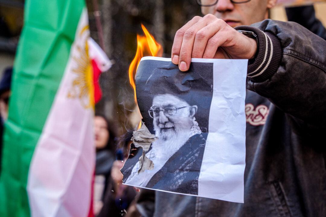 A man burns a photo of Iran’s Supreme Leader Ayatollah Ali Khamenei during a protest at the Iranian Consulate in Milan, Italy, on Jan. 12, 2026. As protests in Iran against the regime stretched beyond two weeks, President Donald Trump on Jan. 13 issued his strongest and most direct message yet in support of protesters. (Claudio Furlan/LaPresse via AP)