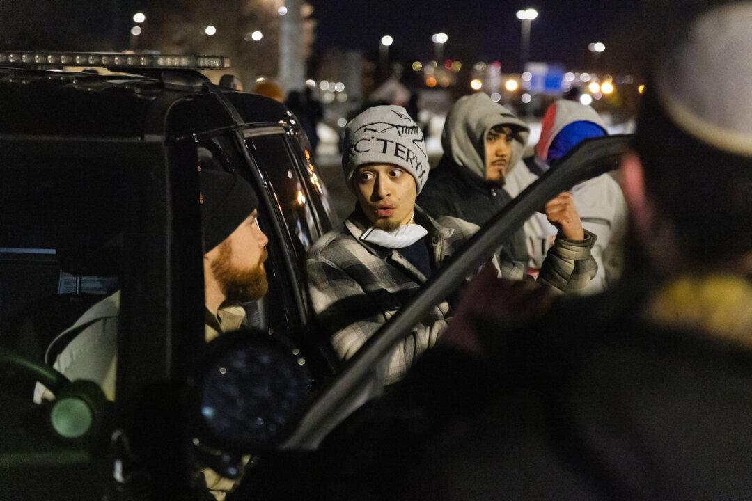 (Top Left) Protesters demonstrate in front of the Bishop Henry Whipple Federal Building in Minneapolis on Jan. 9, 2026. (Top Middle) Federal officers detain a women in front of the Bishop Henry Whipple Federal Building in Minneapolis on Jan. 9, 2026. (Top Right) Protesters demonstrate in front of federal officers and the Bishop Henry Whipple Federal Building in Minneapolis on Jan. 9, 2026. (Bottom Left) Protesters demonstrate in front of federal officers and the Bishop Henry Whipple Federal Building in Minneapolis on Jan. 11, 2026. (Bottom Middle) A protester talks to a sheriff’s deputy (L) in front of the Bishop Henry Whipple Federal Building in Minneapolis on Jan. 11, 2026. (Bottom Right) People protest against federal immigration operations in Minneapolis on Jan 9., 2026. (John Fredricks/The Epoch Times)