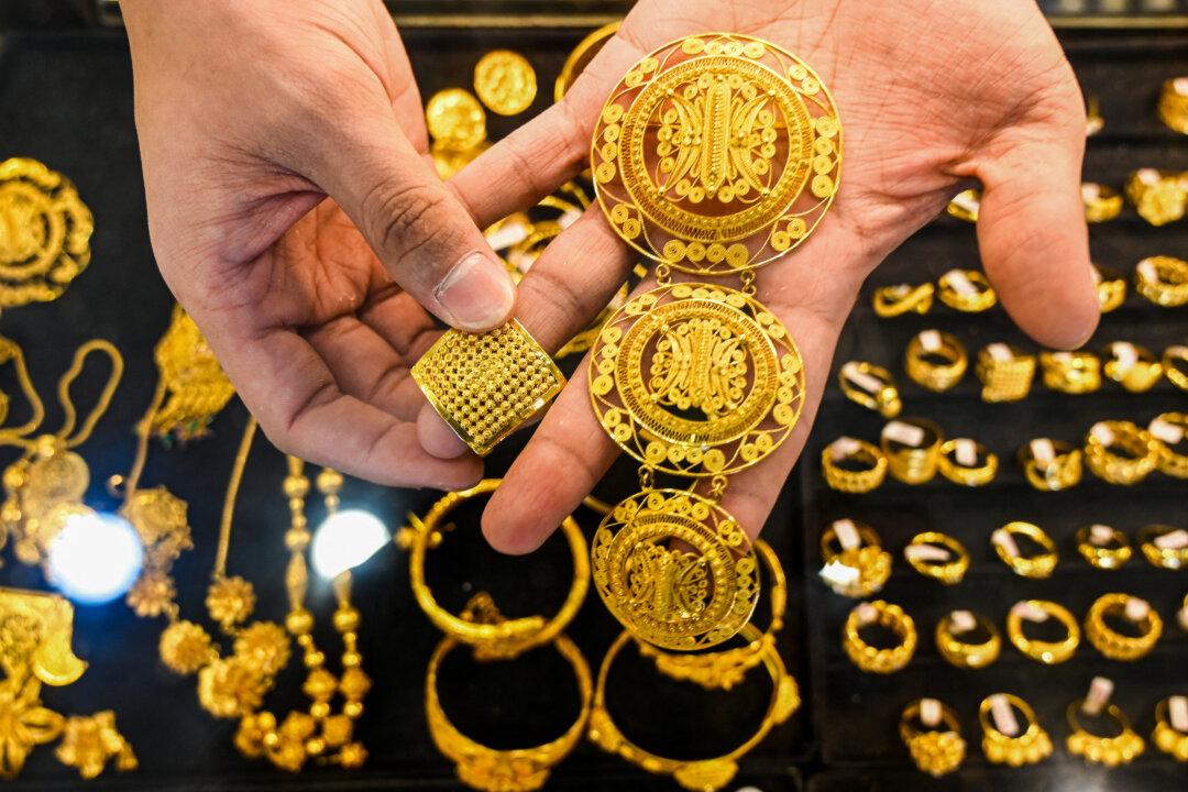 An employee holds pieces of gold jewelry at a jewelry store in Banda Aceh, Indonesia, on Jan. 14, 2026. (Chaideer Mahyuddin/AFP via Getty Images)