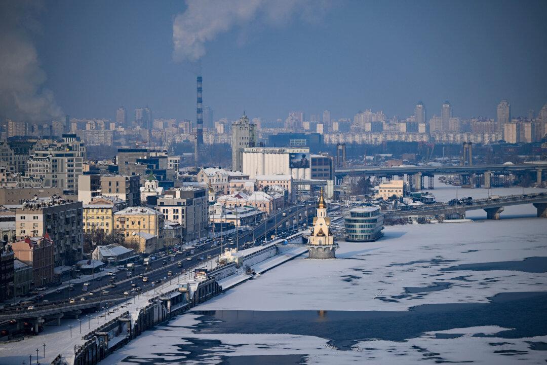 Vehicles are driven on a road along the ice-covered Dnieper River in Kyiv, on Jan. 14, 2026. (Sergei Gapon/AFP via Getty Images)
