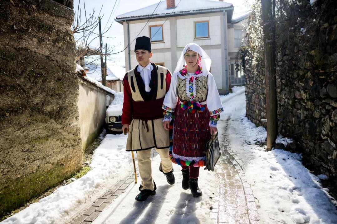 Young people dressed as Groom and Bride characters process around Vevcani village for their Carnival in Vevcani, North Macedonia, on Jan. 14, 2026. The Vevcani Carnival is an annual event held to mark the Orthodox New Year (St. Basil's Day). (Jack Taylor/Getty Images)