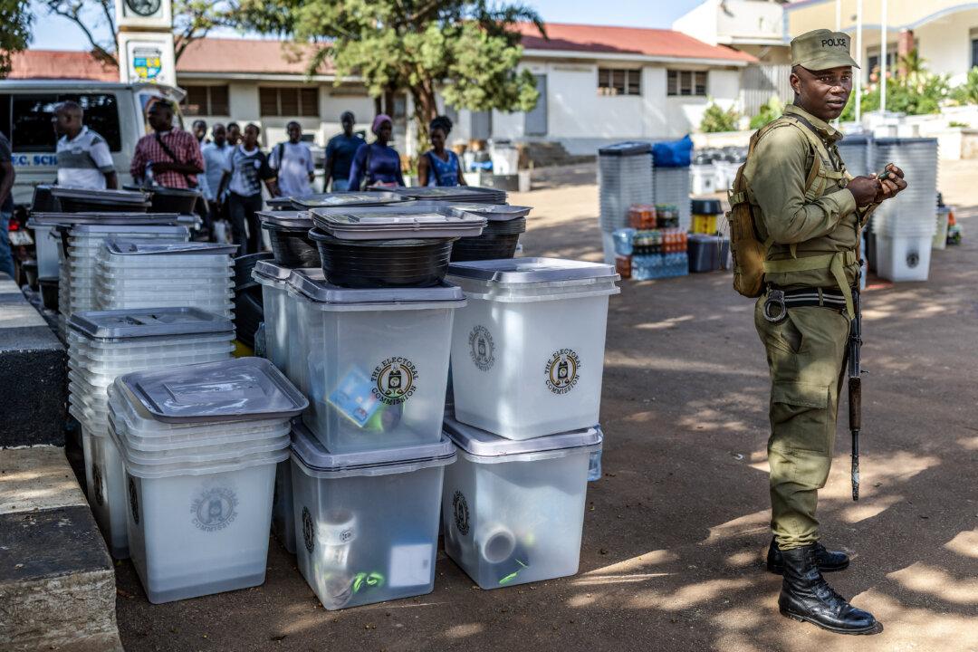 A Ugandan police officer monitors the area while guarding ballot boxes and other electoral materials for dispatch at a polling station serving as a dispatch center during final preparations ahead of Uganda's 2026 general elections, in Kampala, on Jan. 14, 2026. (Luis Tato/AFP via Getty Images)