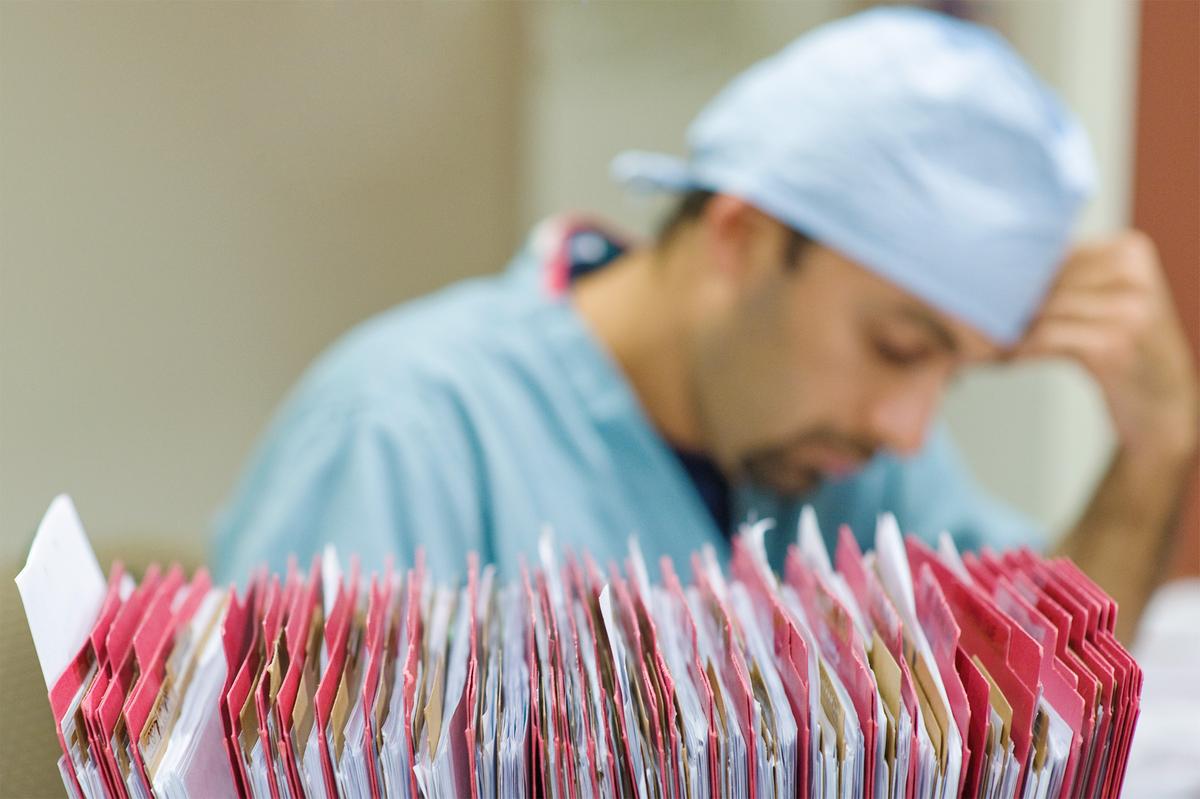As chronic disease rose, paperwork multiplied. Clinicians spend nearly two hours on documentation for every hour of face-to-face care. (Reza Estakhrian/Getty Images)