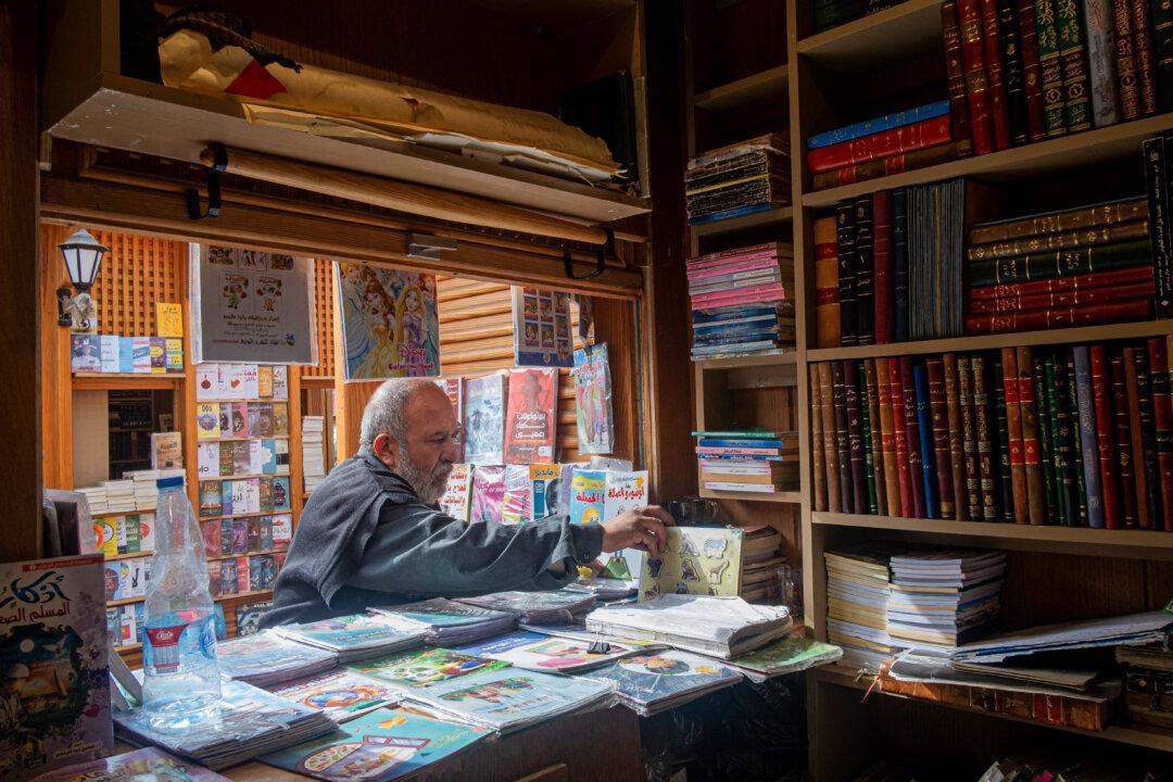An Egyptian second-hand book shop owner arranges his wares in the open-air market specializing in second-hand books, known in Arabic as Soor el-Azbakeya, at Attaba Market in central Cairo, on Jan. 21, 2026. The Egyptian capital's oldest book market, is home to some 130 book stalls that date back to the late 19th century. (Khaled Desouki/AFP via Getty Images)
