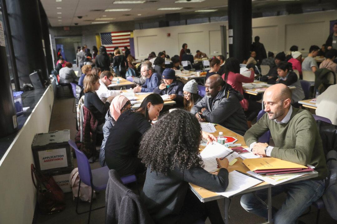 Immigrants receive help with U.S. citizenship applications at an event in New York City on Feb. 3, 2018. In November 2025, the Department of Homeland Security proposed repealing a 2022 public charge rule that prevented officers from considering green card applicants’ use of public benefits such as food stamps (SNAP), the Children’s Health Insurance Program, Medicaid, or housing assistance. (John Moore/Getty Images)