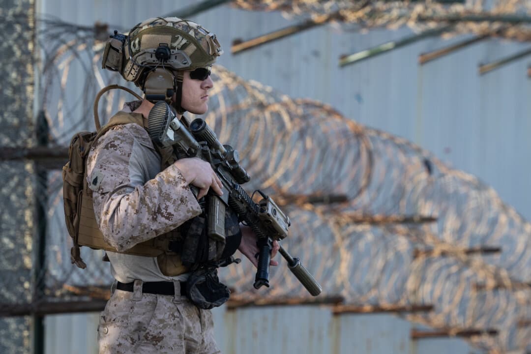 (Left) U.S. Marines patrol the U.S.–Mexico border near San Diego on Jan. 20, 2026. (Right) A sandal caught in barbed wire hangs on the U.S. border wall outside San Diego on Jan. 20, 2026. (John Fredricks/The Epoch Times)