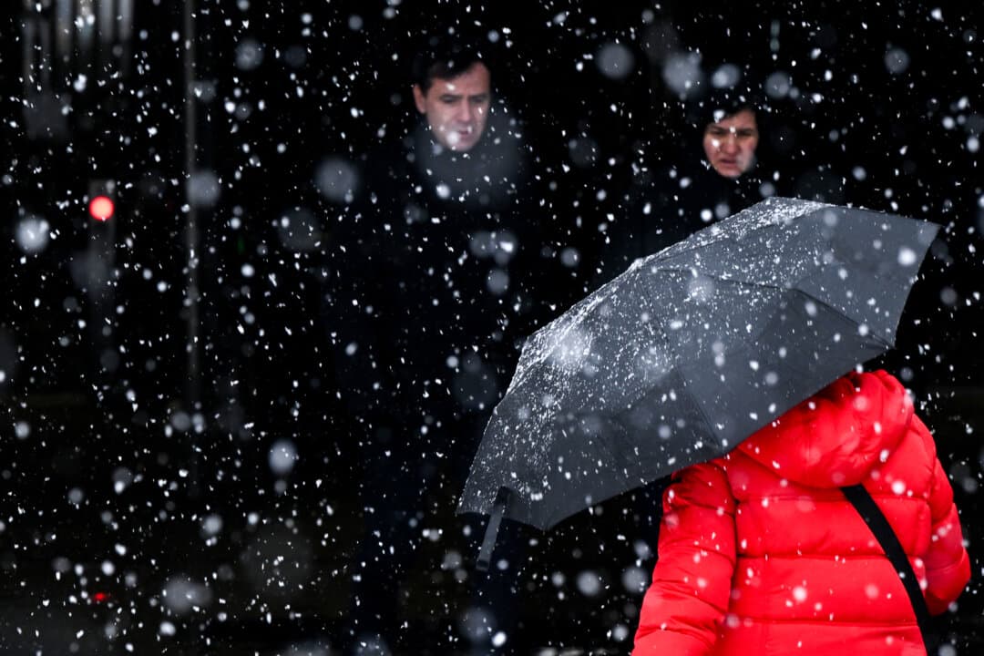A woman with an umbrella enters an underground passage in Frankfurt am Main, Germany, on Jan. 26, 2026, as the air temperature reached 1 degree above zero Celsius. (Kirill Kudryavtsev / AFP via Getty Images)