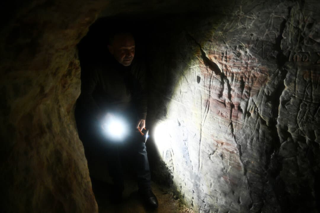 Oleksandr Danevich, an employee of the Kyiv-Pechersk Lavra National Preserve, walks through a subterranean labyrinth of caves at the UNESCO-listed monastery in Kyiv, Ukraine, on Jan. 26, 2026. A Russian drone and missile attack has damaged parts of the Kyiv-Pechersk Lavra, Ukraine's most famous religious landmark and a UNESCO World Heritage Site, Ukraine's culture ministry said. (Genya Savilov / AFP via Getty Images)