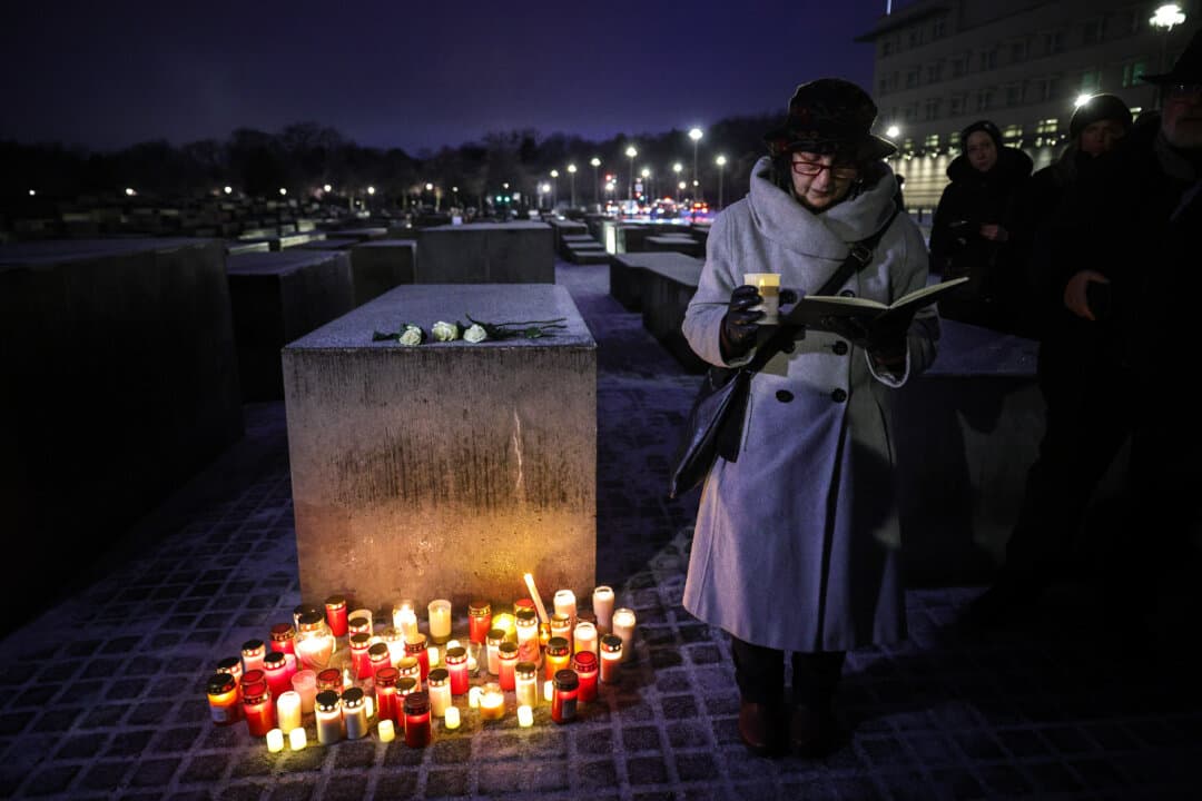 A woman recites the Mourner's Kaddish prayer on Jan. 26, 2026, the eve of Holocaust Memorial Day at a gathering to light candles at the Memorial to the Murdered Jews of Europe in Berlin, Germany. Holocaust Memorial Day on Jan. 27 commemorates the six million Jews and other victims murdered by Nazi Germany. (Omer Messinger/Getty Images)