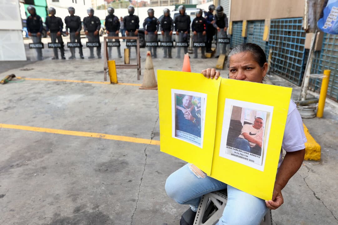 A woman holds pictures of her loved ones while waiting for news on the release of prisoners, outside of Zone 7 of the Bolivarian National Police in Sucre municipality, Metropolitan District of Caracas, Venezuela, on Jan. 26, 2026. More than 100 political prisoners were freed in Venezuela, where detainees are slowly being released under pressure from the United States, the nongovernmental organization Foro Penal said. (Pedro Mattey / AFP via Getty Images)
