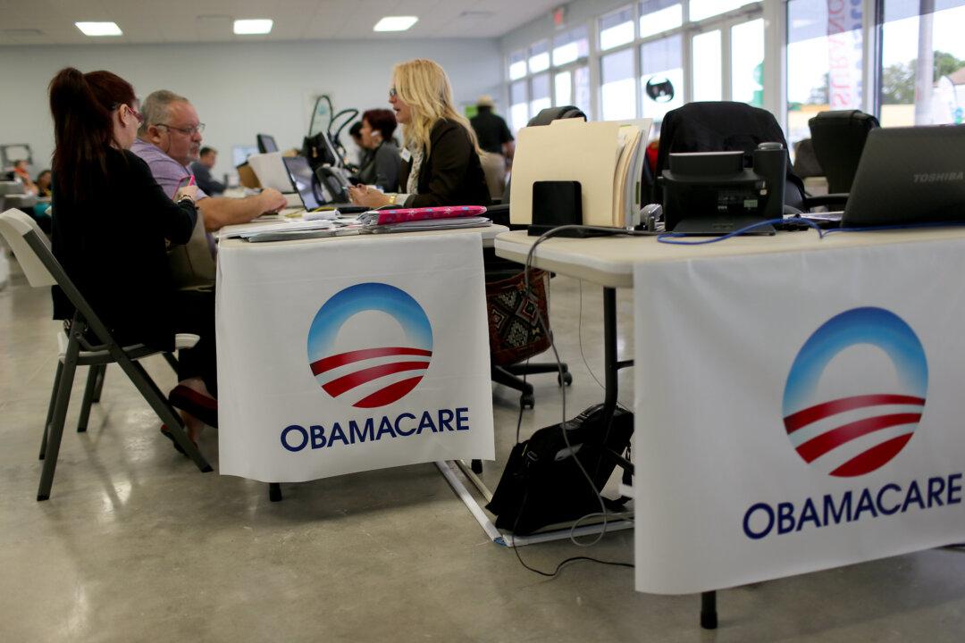 People meet with an insurance advisor as they sign up for the Affordable Care Act, also known as Obamacare, in Miami on Feb. 5, 2015. Data indicate the cost of insuring Obamacare enrollees exceeded expected levels in the early years. (Joe Raedle/Getty Images)