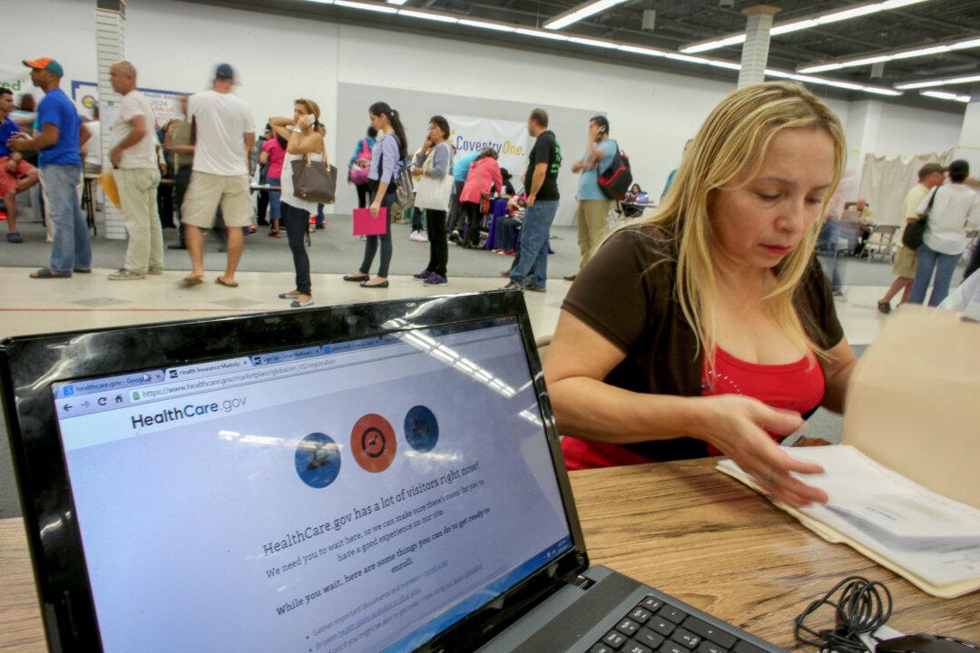 A customer meets with a Sunshine Life and Health Advisors agent while waiting for the Affordable Care Act website to come back online to purchase a health insurance plan in Miami on March 31, 2014. (Joe Raedle/Getty Images)