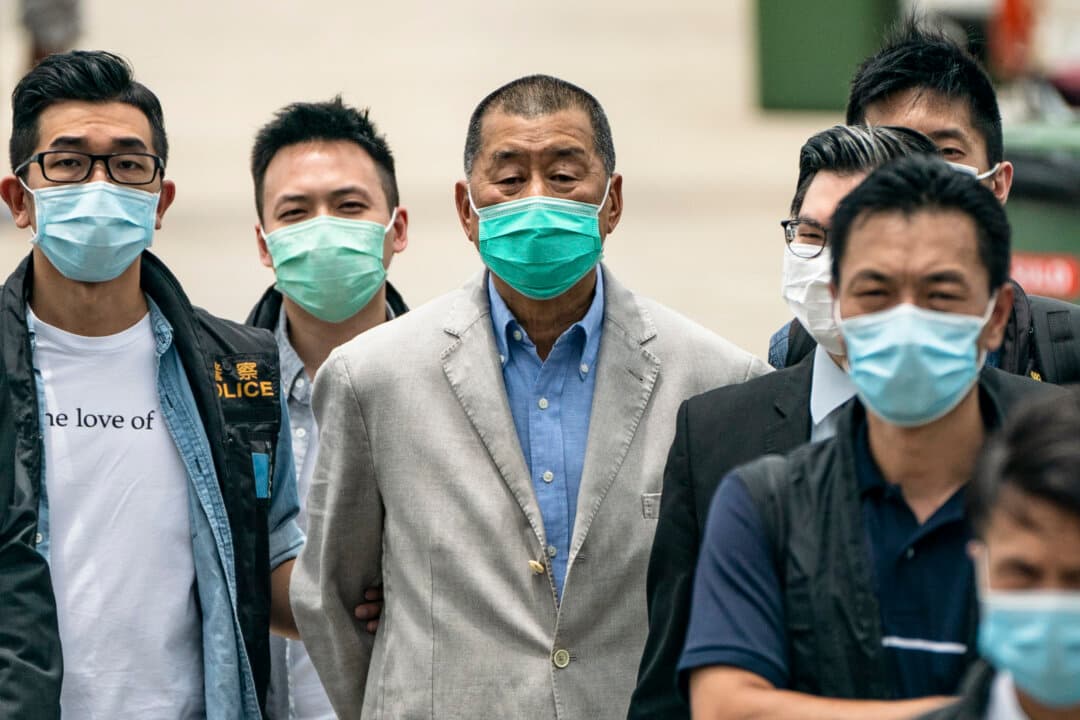 Police escort Hong Kong media tycoon Jimmy Lai to the Royal Hong Kong Yacht Club Shelter Cove Clubhouse in Hong Kong, China, on Aug. 11, 2020. Lai was convicted under Hong Kong’s National Security Law late last year and sentenced to 20 years in prison. (Anthony Kwan/Getty Images)
