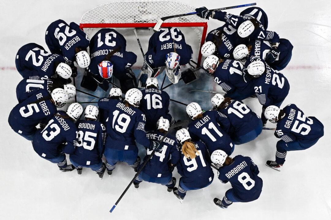 France's players gather prior to the women's preliminary round Group B Ice Hockey match between Germany and France at the Milano Rho Ice Hockey Arena at the Milan Cortina 2026 Winter Olympic Games in Milan, on Feb. 9, 2026. (Alexander Nemenov/AFP via Getty Images)