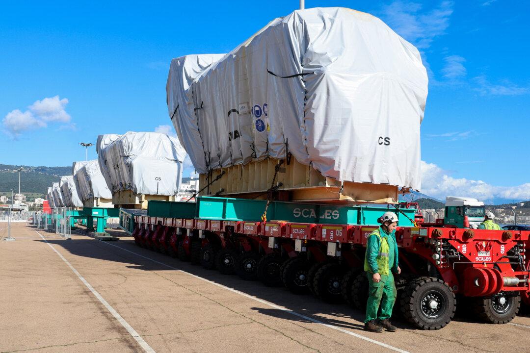 Workers unload a biofuel engine from a bunkering vessel at Ajaccio's port prior to their installation at the new Ajaccio Ricanto electric central, on the French Mediterranean island of Corsica, on Feb. 10, 2026. (Pascal Pochard-Casabianca/AFP via Getty Images)