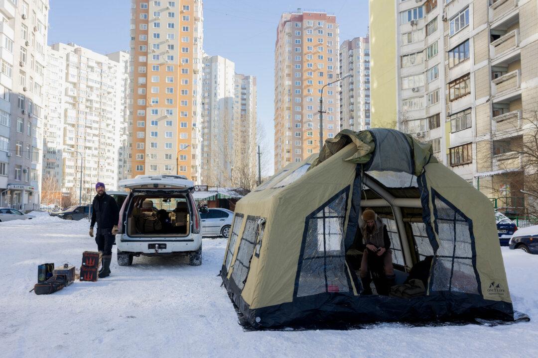 Artemiy and his wife, Marina, are preparing a dry sauna set-up in a residential neighborhood in Kyiv on Feb. 10, 2026, for those whose homes are without electricity or heating following Russian missile and drone attacks on Ukrainian energy infrastructure amid the Russian invasion of Ukraine. (Tetiana Dzhafarova/AFP via Getty Images)