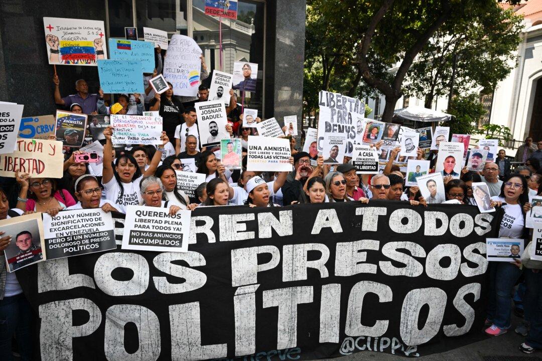 Relatives of political prisoners hold a banner reading “Release all political prisoners” as they demonstrate in front of the national parliament building in Caracas, Venezuela, on Feb. 10, 2026. (Federico Parra/AFP via Getty Images)