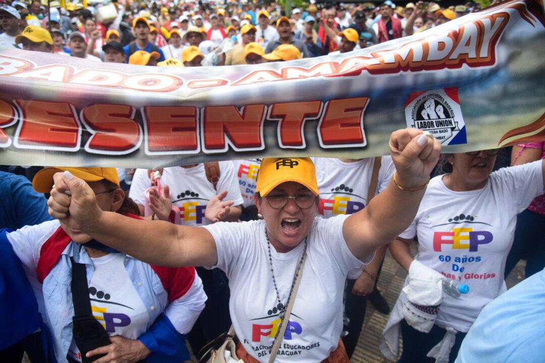 Teachers take part in a protest against a bill to reform the public sector pension system and raise the retirement age, alongside retired police officers and military members, near the Congress building in Asuncion, Paraguay, on Feb. 10, 2026. (Daniel Duarte/AFP via Getty Images)