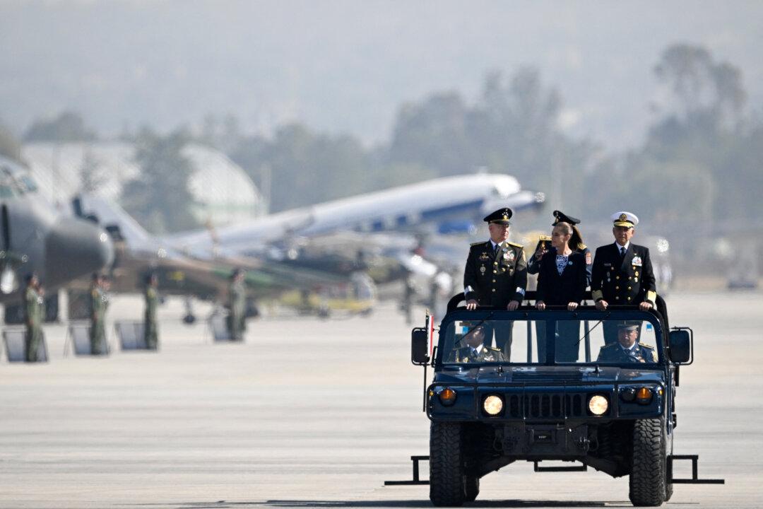Mexico's President Claudia Sheinbaum arrives with Army General Ricardo Trevilla Trejo of the Defense Ministry and Navy Admiral Raymundo Pedro Morales of the Navy Ministry for an Air Force ceremony marking its 111th anniversary at the Santa Lucia Air Force Base in Zumpango, near Mexico City, on Feb. 10, 2026. (Alfredo Estrella/AFP via Getty Images)