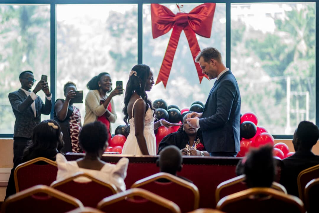 Couples exchange vows and rings in a ceremony led by a commissioner for Civil Registration at the National Identification and Registration Authority (NIRA) in Kampala, Uganda, on Feb. 13, 2026. Representing Uganda, Congo, and Eritrea, 14 couples participated in a special Valentine's Day event organized by NIRA. Although many couples prefer to marry on the actual Valentine's Day, the ceremony was held a day early due to NIRA's being closed on Saturday. (Badru Katumba/AFP via Getty Images)