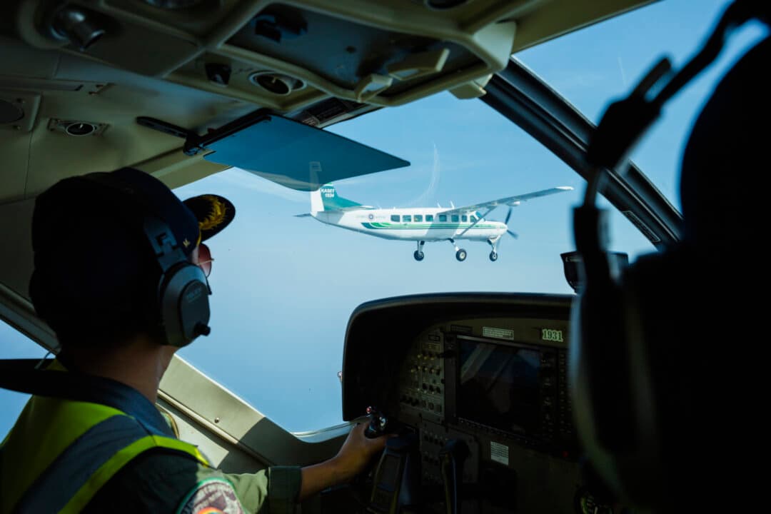 AR23, a chemical mix, is dispensed through a pipe at the bottom of a small aircraft, seen from the cockpit in Hua Hin, Thailand, on Feb. 13, 2026, as the Royal Rainmakers take to the skies over Bangkok. With air pollution levels reaching toxic levels at the start of each year, pollution pilots and ground staff dispense a mixture of sodium chloride and calcium chloride, as well as dry ice, to create artificial rain or increase atmospheric air circulation in a bid to clear the air on the ground. (Mailee Osten-Tan/Stringer/Getty Images)