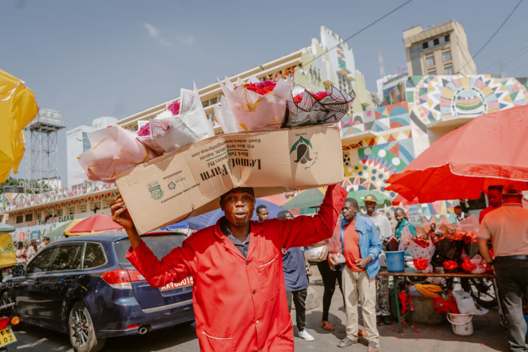 A vendor balances a box full of flower bouquets on his head outside City Market in downtown Nairobi, Kenya, on Feb. 14, 2026. (Fredrik Lerneryd/AFP via Getty Images)
