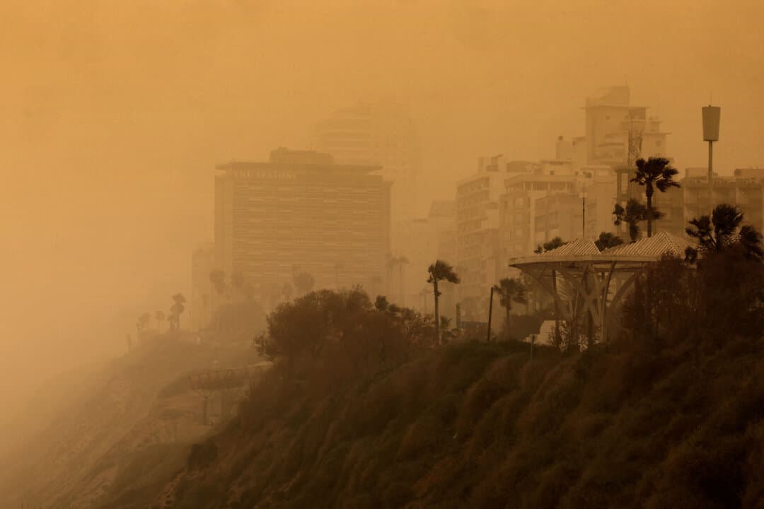 A photograph shows buildings on the shoreline during hazy and dusty weather in Netanya, Israel, on Feb. 14, 2026. (Jack Guez/AFP via Getty Images)