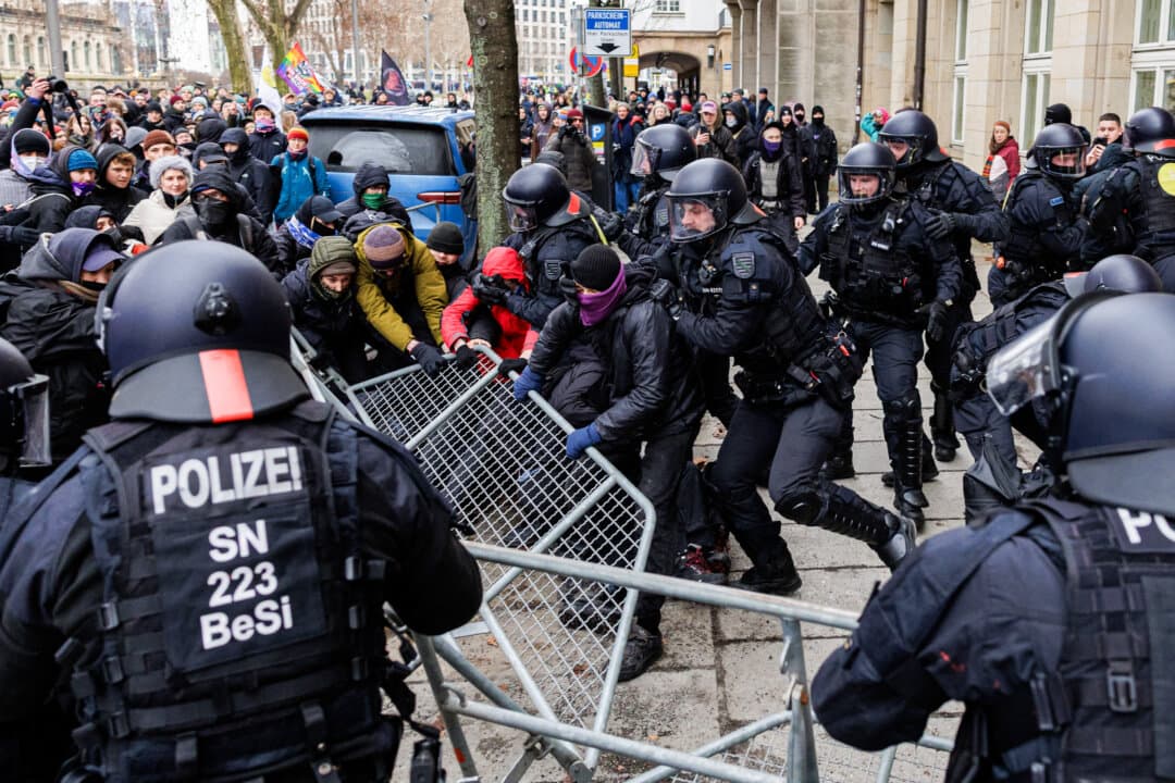 Policemen prevent participants in a left-wing demonstration from removing a barrier fence as they protest against a planned right-wing march in Dresden, Germany, on Feb. 14, 2026. (Jens Schlueter/AFP via Getty Images)