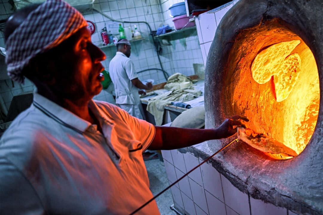 Men prepare pita bread at a traditional bakery in Souq Bab al-Bahrain in Manama, Bahrain, on Feb. 14, 2026. (Giuseppe Cacace/AFP via Getty Images)