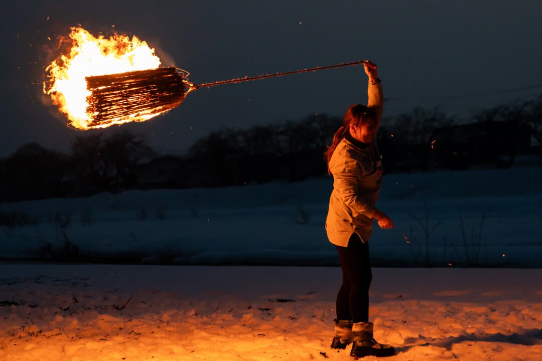 A participant swings a charcoal sack around her body near a snow dome, known as a kamakura, during the Kakunodate Hiburi Kamakura snow festival in Senboku, Akita prefecture, Japan, on Feb. 14, 2026. (Tomohiro Ohsumi/Getty Images)