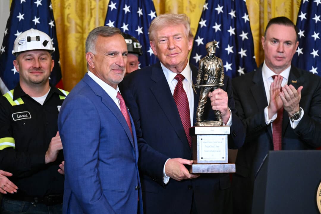 President Donald Trump poses with “The Undisputed Champion of Beautiful Clean Coal” trophy handed to him by Jim Grech (2nd L), CEO of Peabody Energy, at a “Champion of Coal” event at the White House on Feb. 11, 2026. (Saul Loeb/AFP via Getty Images)