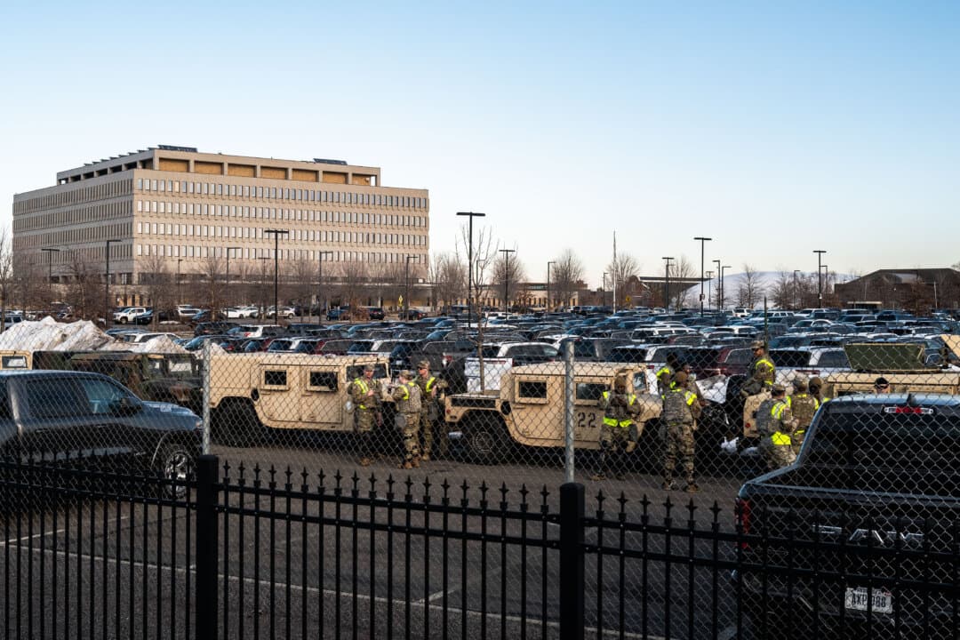 Members of the Minnesota National Guard stage in the parking lot outside the Bishop Henry Whipple federal building in Minneapolis on Feb. 13, 2026. A day before, White House border czar Tom Homan announced that the federal immigration enforcement surge in Minnesota would conclude. (Stephen Maturen/Getty Images)
