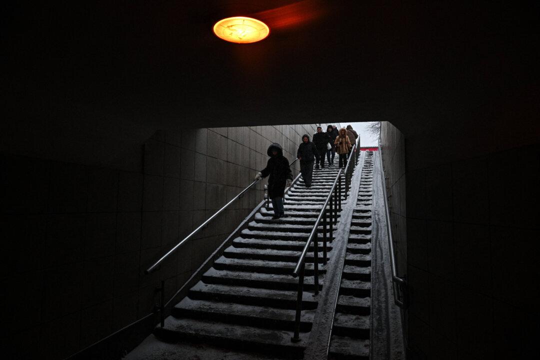 People walk down the stairs at a metro station in Moscow on Feb. 16, 2026. (Hector Retamal/AFP via Getty Images)