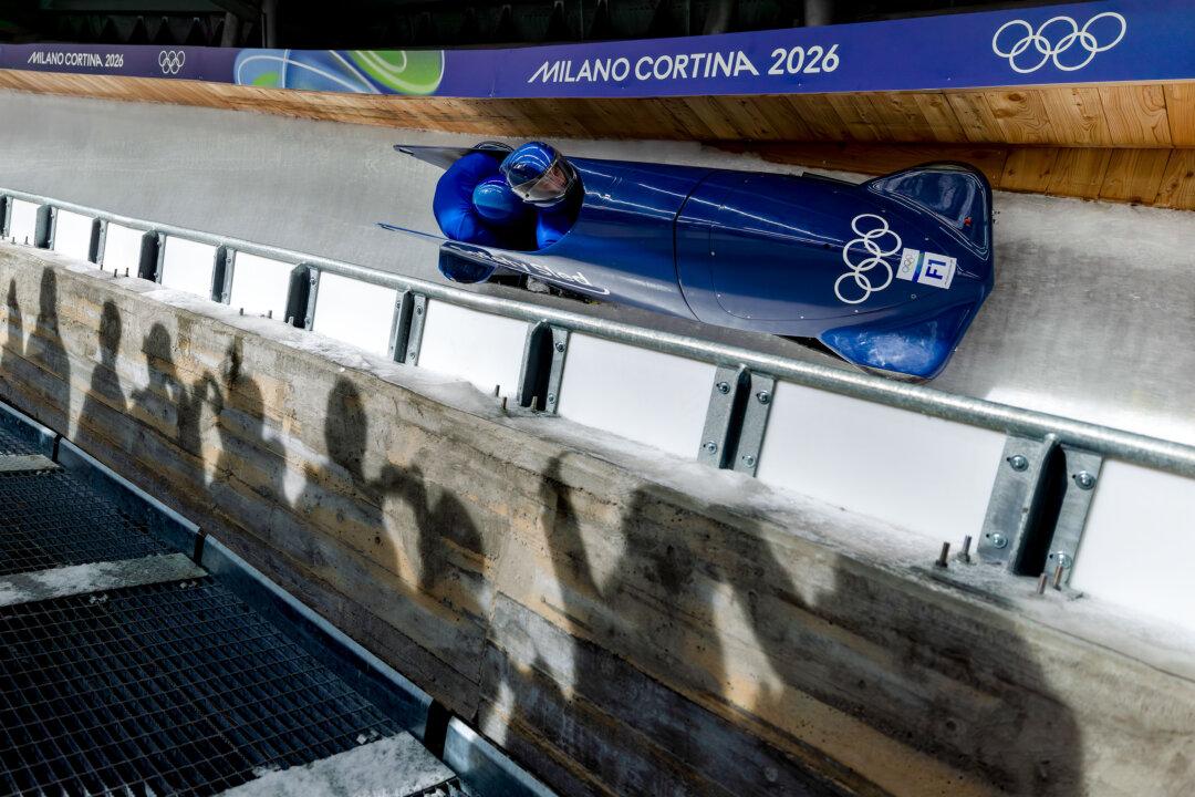A forerunner pilots prior to the men's two-man bobsled Heat 2 on Day 10 of the Milano Cortina 2026 Winter Olympic games at Cortina Sliding Center in Cortina d'Ampezzo, Italy, on Feb. 16, 2026. (Al Bello/Getty Images)