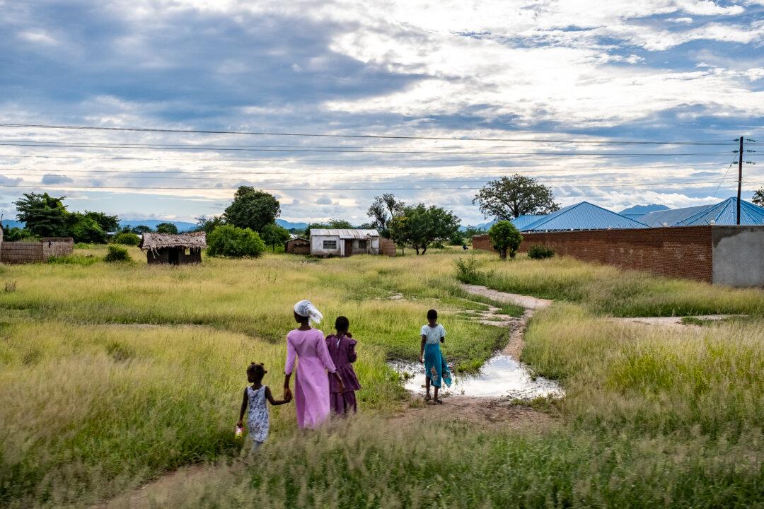 People walk on a roadway outside of Blantyre, Malawi, on Feb. 17, 2026. (John Fredricks/The Epoch Times)