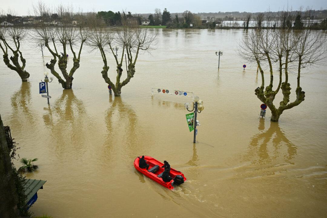 Employees patrol by boat near the city center flooded by the Garonne river in La Reole, France, on Feb. 17, 2026. The flood alert system has been working at a record pace as relentless rain over the past month has saturated the soil, the head of the agency told AFP on Feb. 14. (Gaizka Iroz/AFP via Getty Images)